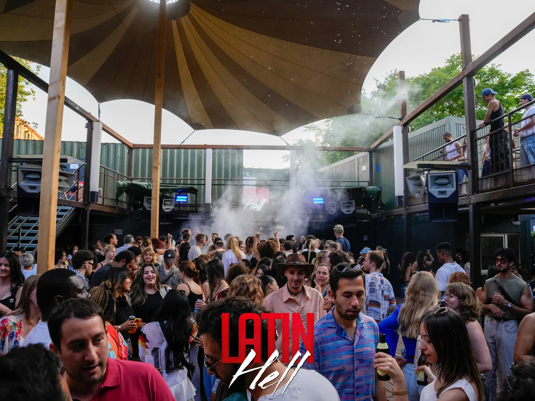 Gäste feiern gemeinsam unter dem Sonnensegel bei einer Latin Hell Tagesparty